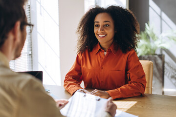 Young woman having job interview with a recruiter and smiling