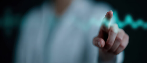 Person pointing at digital heartbeat line, symbolizing technology in healthcare