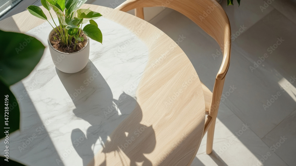 Poster Sunlight illuminates a minimalist dining setting: a round table with a marble top and light wood base, accompanied by a simple wooden chair, and a small potted plant adding a touch of  : Generative AI