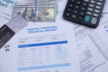 Obraz premium Financial documents, credit cards, cash, and a calculator arranged on a desk for monthly personal budgeting.