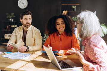 Diverse business team collaborating on project in modern office