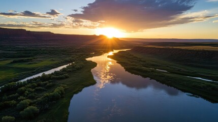 Sunset over a meandering river in a canyon landscape, reflecting golden light on calm water, surrounded by lush green vegetation and red rock formations. : Generative AI