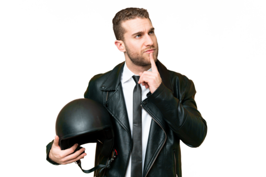 Business man with a motorcycle helmet over isolated chroma key background having doubts while looking up