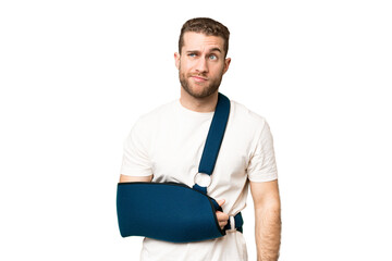 Young handsome blonde man with broken arm and wearing a sling over isolated chroma key background...