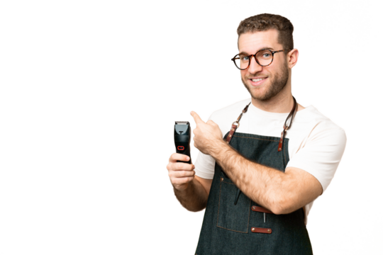 Barber man in an apron over isolated chroma key background pointing back