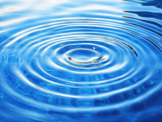 A single drop creates concentric ripples on a calm, blue water surface, reflecting light and creating a mesmerizing pattern of circular waves. : Generative AI