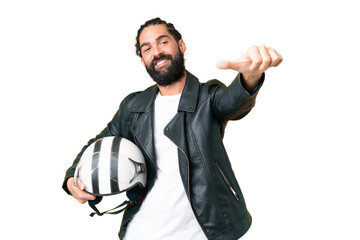 Naklejka premium Young man with beard with a motorcycle helmet over isolated chroma key background giving a thumbs up gesture