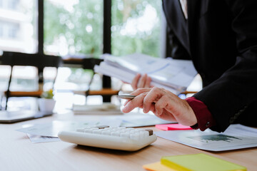 Young asian business man audit analysis graph company budget report, assigned accounts receivable, production control, operational audit, cost plus pricing