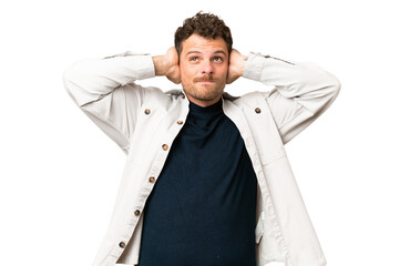 Brazilian man over isolated chroma key background frustrated and covering ears