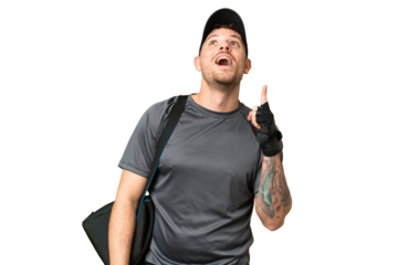 Young sport man with sport bag over isolated chroma key background pointing up and surprised