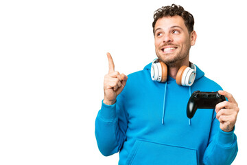 Brazilian man playing with a video game controller over isolated chroma key background intending to realizes the solution while lifting a finger up © luismolinero