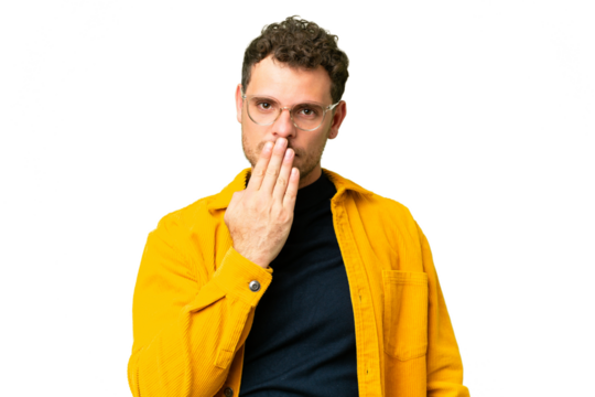 Brazilian man over isolated chroma key background covering mouth with hand
