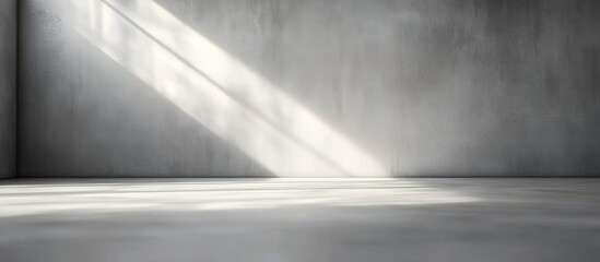 Empty gray cement-walled room with diagonal sunlight shadows.