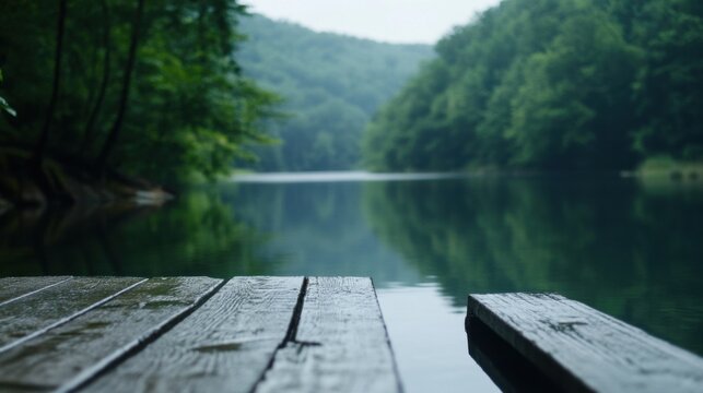 Serene lake view from a wooden dock, extending over calm water reflecting lush green forest hills on a misty day. : Generative AI
