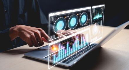 Businessman interacts with futuristic digital analytics graphs and data visualizations projected from a laptop.