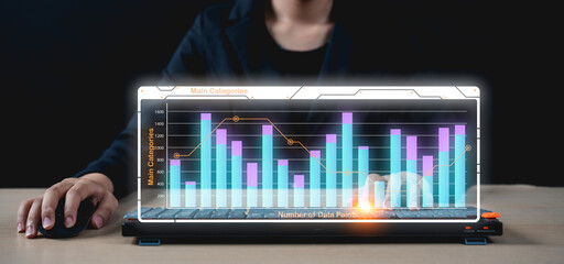 Businessman interacts with a futuristic laptop displaying a holographic bar and line graph for data analysis.