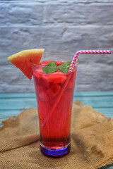 Refreshing watermelon and kiwi cocktail on a wooden board evoking a summer atmosphere