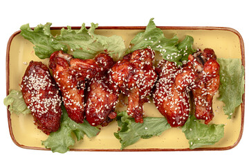 Portion of cooked chicken wings in sauce and sesame seeds