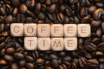 Coffee time in wooden blocks surrounded by espresso beans
