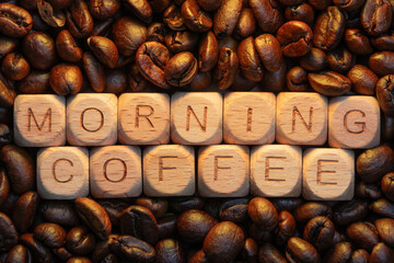 Wooden blocks spelling 'morning coffee' surrounded by roasted coffee beans