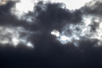 Dark storm clouds with sun behind