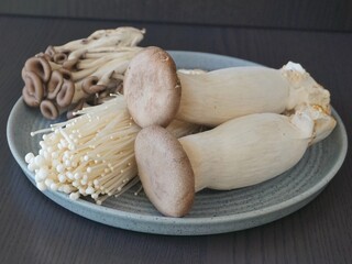 Enoki Mushroom, Oyster mushroom (pleurotus ostreatus) on a dark background, cooking. Asian cuisine. 팽이버섯, 새송이 버섯, 팩느타리 버섯.