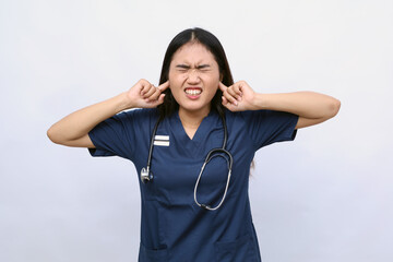 Beautiful young doctor woman wearing medical uniform over isolated background covering ears with...