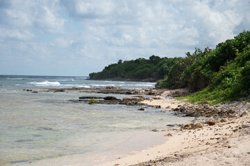Caribbean sea ocean waves washing up on a rocky beach in Trelawny, Jamaica.