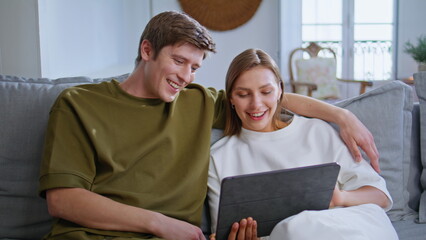 Teen couple looking tablet computer in house closeup. Loving people at home