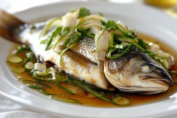 Cantonese Steamed Whole Fish, asian barramundi steam fish, traditional chinese steamed whole seabass fish garnished with ginger and scallions in aromatic sauce