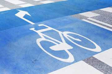 Bicycle lane road marking. Blue painted bike path. White bicycle symbol with arrow. Urban...