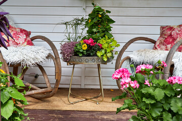 View of a garden flower arrangement on a coffee table on a summer veranda in a garden
