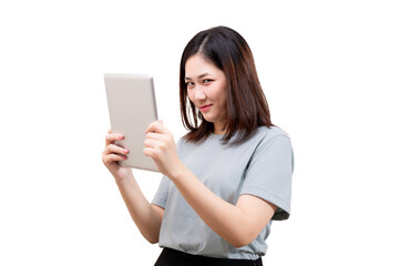 Naklejka premium Asian beautiful woman wearing blue t-shirt holds and looks at a tablet, appearing engaged and focused.