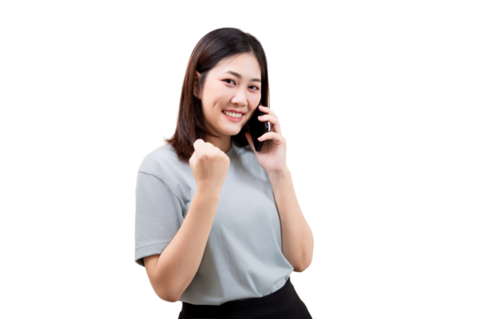 A woman smiles while talking on a phone and makes a fist gesture in a sign of success or excitement.