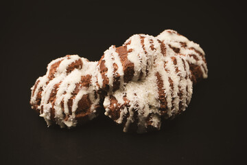 Profiteroles with coconut cream on a black background.