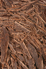 A close-up shows a pile of dark chocolate shavings with a rich, textured surface