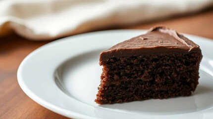 A slice of chocolate cake filled and topped with rich chocolate frosting, placed on a white plate, realistic food photography.