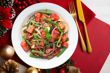 Summer salad with watermelon, fennel and green beans. Top view table with christmas decorations.