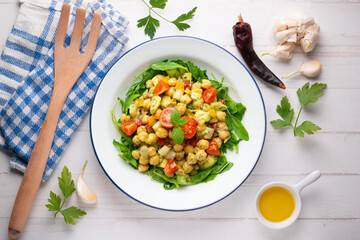 Mediterranean chickpea salad with avocados and vegetables. Top view table with christmas decorations.