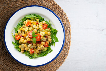 Mediterranean chickpea salad with avocados and vegetables. Top view table with christmas decorations.