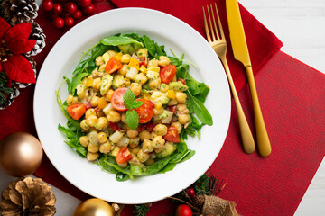 Mediterranean chickpea salad with avocados and vegetables. Top view table with christmas decorations.