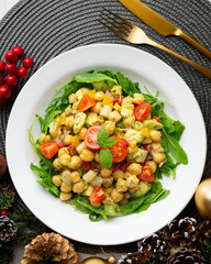 Mediterranean chickpea salad with avocados and vegetables. Top view table with christmas decorations.