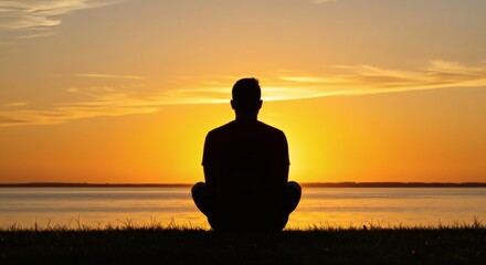 AI image of a person's silhouette meditating in a seated lotus position on grass, facing a vibrant orange sunset over water.