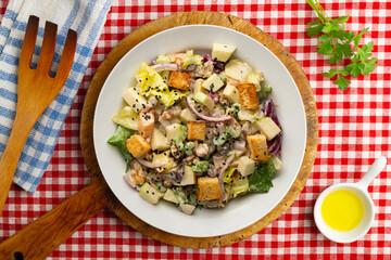 Waldorf salad with apple, raisins, walnuts, and mayonnaise dressing. Top view table with christmas decorations.