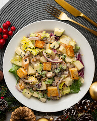 Waldorf salad with apple, raisins, walnuts, and mayonnaise dressing. Top view table with christmas decorations.