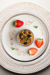 Greek yogurt with strawberries and granola made with cereals and nuts. Top view table with christmas decorations.