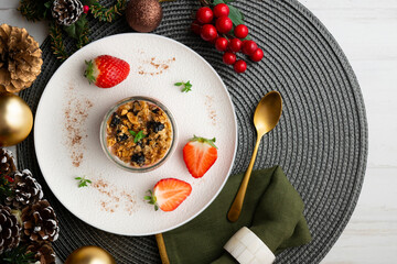 Greek yogurt with strawberries and granola made with cereals and nuts. Top view table with christmas decorations.