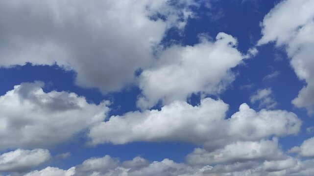 Un cielo de azul con varias nubes de color blanco y gris con un movimiento lento