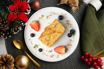 Ibizan Greixonera. Egg pudding with traditional ensaimada from the Balearic Islands. Top view table with christmas decorations.