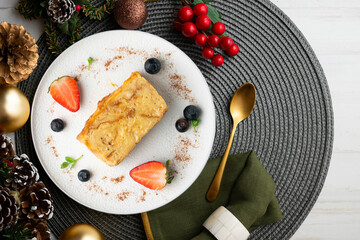 Ibizan Greixonera. Egg pudding with traditional ensaimada from the Balearic Islands. Top view table with christmas decorations.